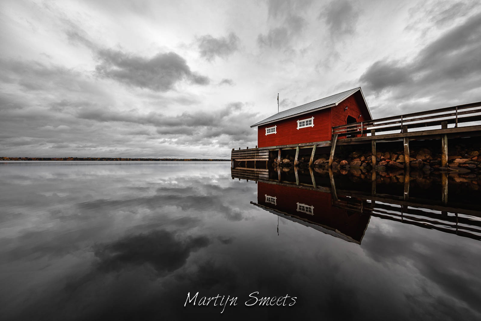 Red boathouse on a pier at lake Siljan, Sweden.
